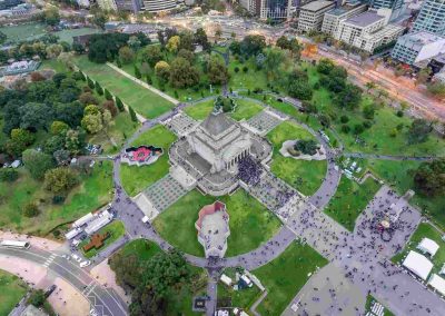 Aerial view of Shrine amid gardens and paths, with a crowd gathering nearby.